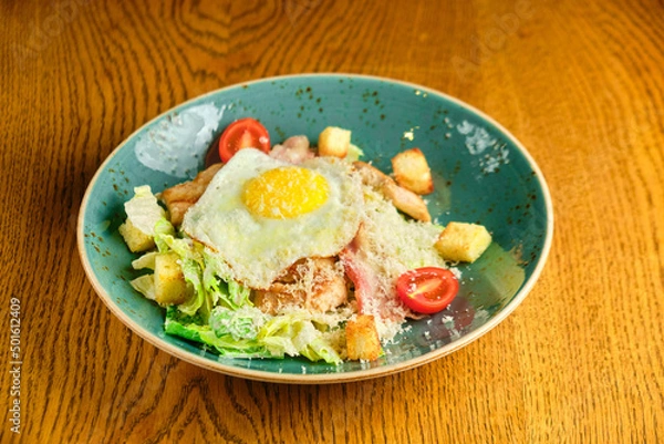 Obraz Caesar salad with large fried eggs