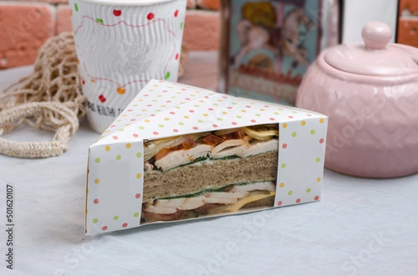 Fototapeta Ham sandwich in a cardboard box with a transparent window. Snack for delivery