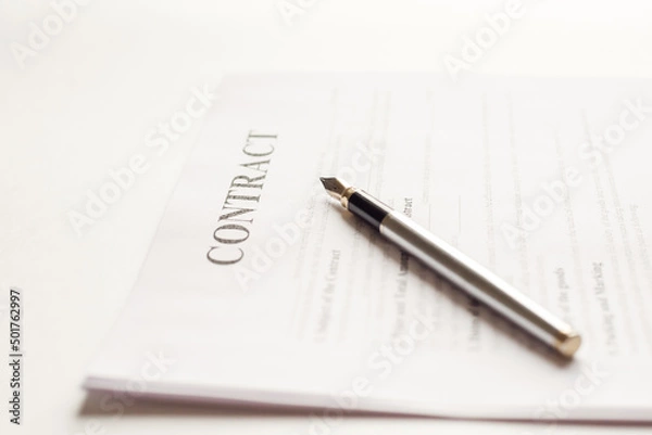 Fototapeta Ink pen lying on a contract or application form, low angle view.