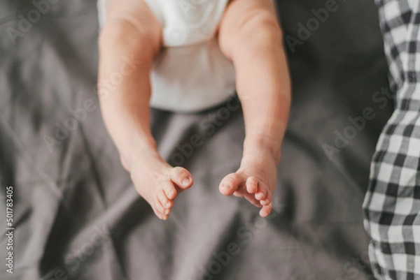 Fototapeta Close up of newborn feet. Soft focus. Grey and white colors.