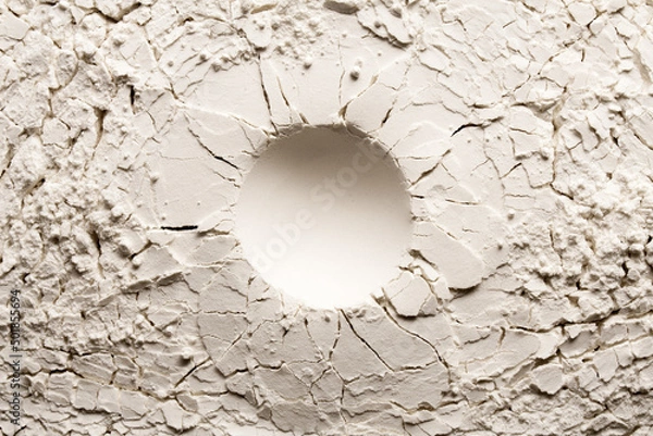 Fototapeta Round crater on white backgroung with crack. Cracked background with a round hole.