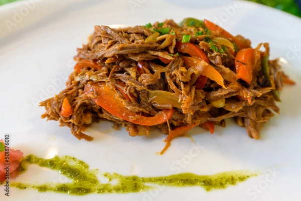 Fototapeta Ropa vieja, traditional Cuban national dish made of shredded beef and vegetables with tomato based sauce, peppers and onions served in a restaurant in Old Havana

