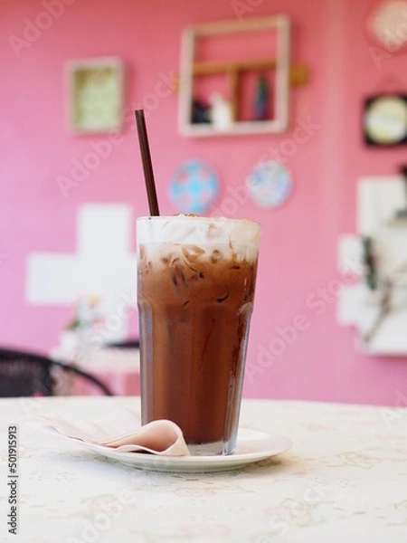 Obraz Ice coffee in a tall glass with cream poured over and coffee beans.