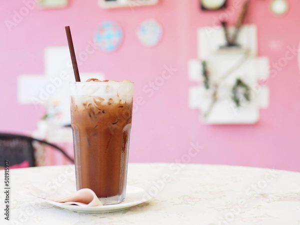 Obraz Ice coffee in a tall glass with cream poured over and coffee beans.