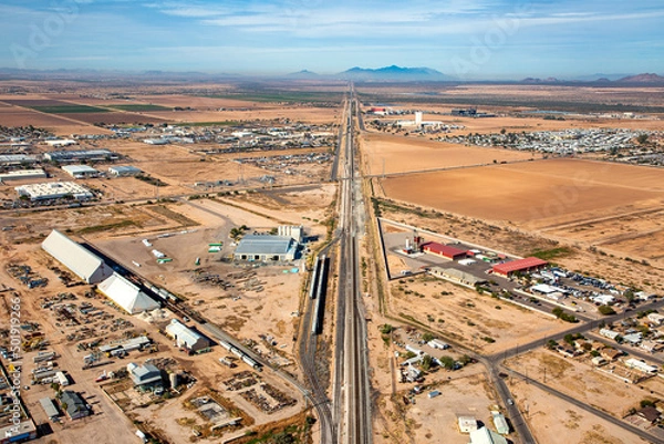 Fototapeta Casa Grande, Arizona agricultural and industrial area viewed along railroad tracks from above
