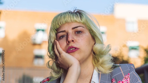 Fototapeta Mujer de pelo corto apoyando la cabeza en la mano, mujer pensativa e indecisa, retrato de mujer de pelo verde