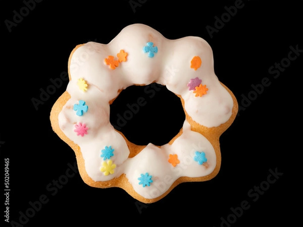 Fototapeta Cookies in the form of a ring in glaze and confetti on a black background.