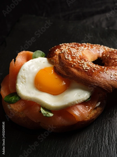 Fototapeta bagel with salmon, egg and basil.