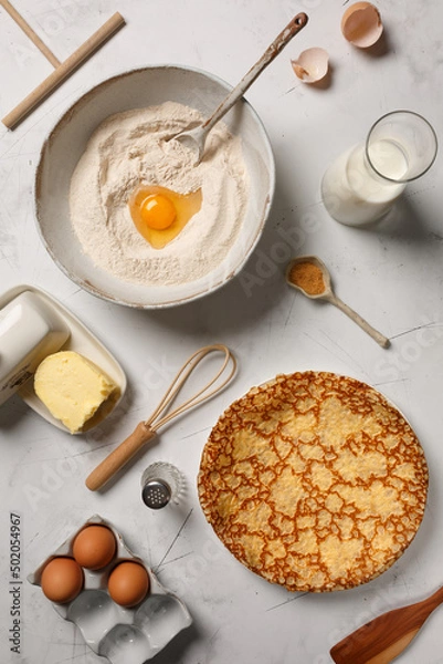 Obraz Préparation la pâte pour crêpes, blinis, pancakes. Les ingrédients sur une table: beurre, oeufs, farine, lait, sucre, sel.