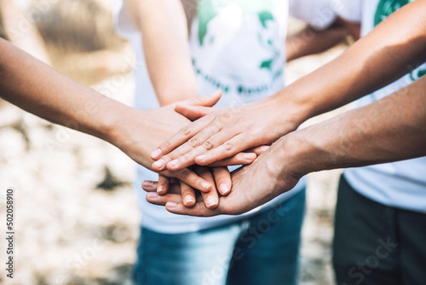 Fototapeta Close up of people volunteer teamwork putting hands together,Stack of hands,Unity and teamwork on world environment day.