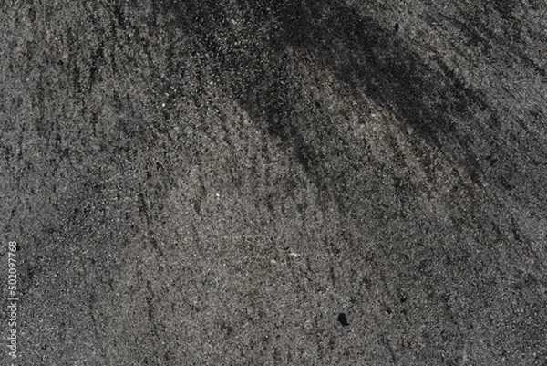 Fototapeta Asphalt texture with white line and tire marks. Smooth asphalt road. Tarmac dark grey grainy road background.Top view
