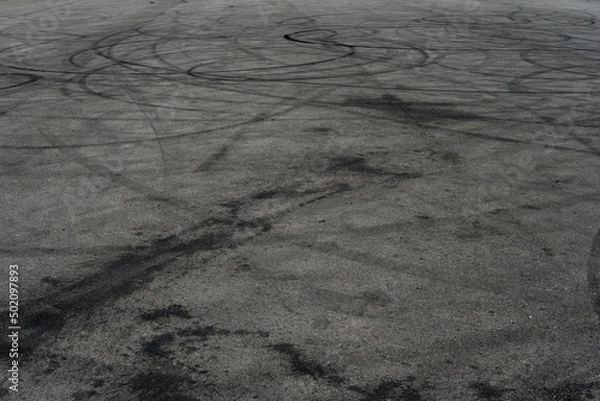 Fototapeta Asphalt texture with white line and tire marks. Smooth asphalt road. Tarmac dark grey grainy road background.Top view