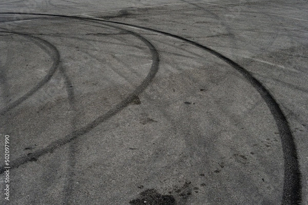 Fototapeta Asphalt texture with white line and tire marks. Smooth asphalt road. Tarmac dark grey grainy road background.Top view