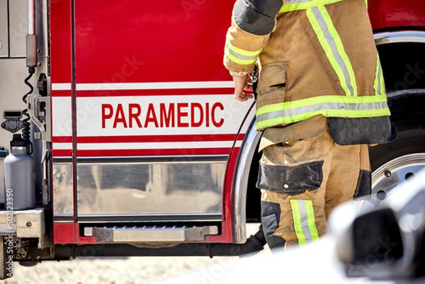 Obraz Fire Fighter paramedic standing by truck