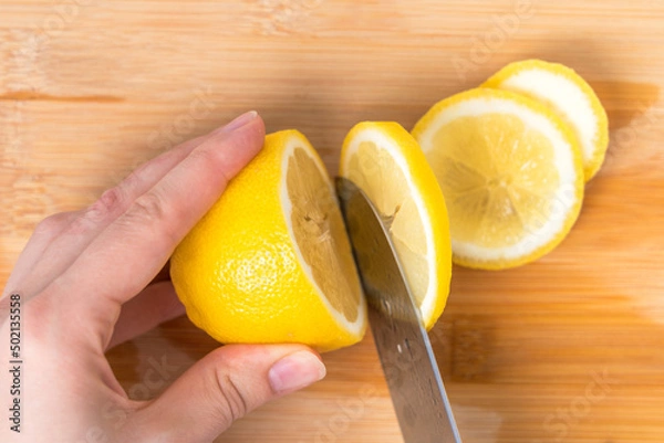 Obraz Cook slices lemon slices, top view