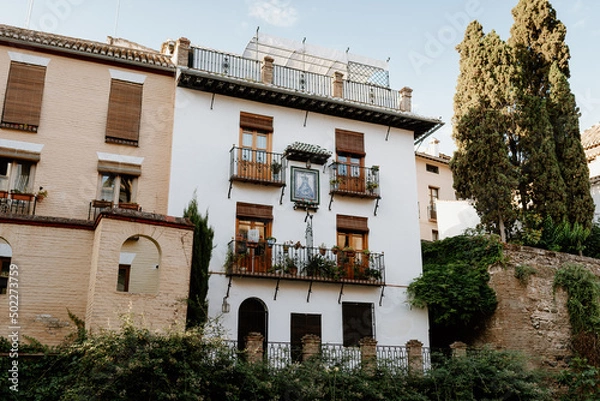Obraz Facade of a house in the Albaicín neighborhood, Granada, with a typical Andalusian balcony full of flowers.