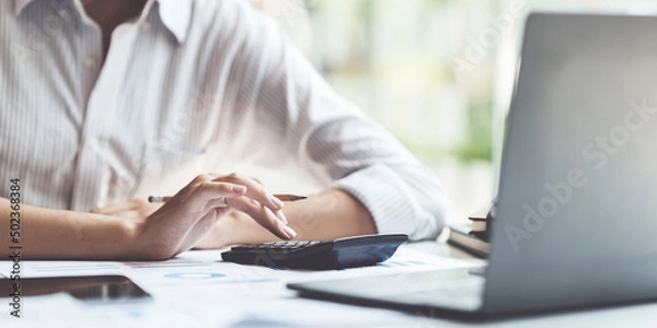 Fototapeta Asian Businessman working to analyze technical price graph and indicator. account or saving money or insurance concept.