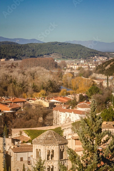 Fototapeta Girona and mountains view from the old wall on a sunny day.