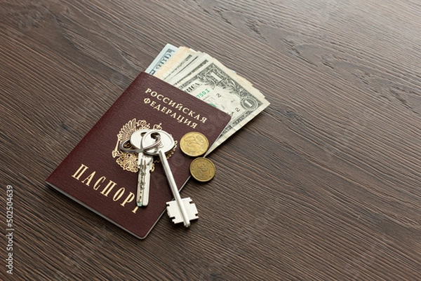 Fototapeta On the table there is a Russian passport inside various dollar bills and small change. House keys