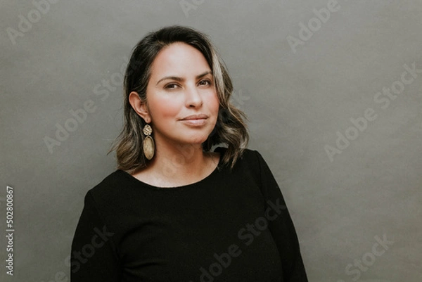 Fototapeta Middle aged hispanic woman standing in front of gray background with inspiring look