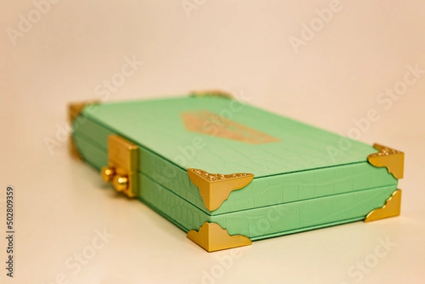 Fototapeta The concept of Valentine's Day. The concept of brand presentation and packaging. Black Friday, sale. Side view of a closed leather cosmetic bag with gold corners. A luxury purchase. Cosmetic products