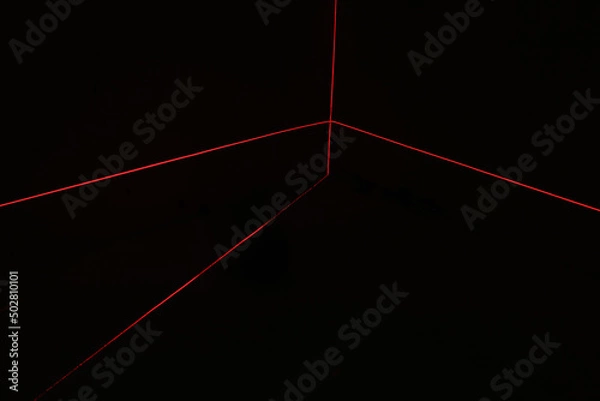 Obraz Red laser beams on black background
