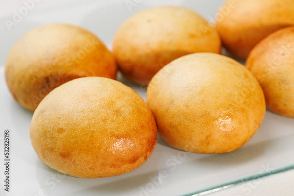 Fototapeta pão de batata assado e fresquinho sobre prato branco 