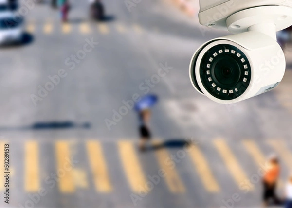 Obraz CCTV camera pointing on the road blurred background. artificial intelligence . secutity concept .