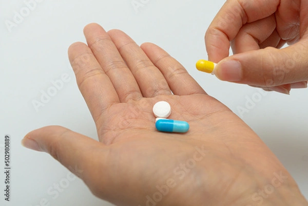 Fototapeta Concept on the palm of the hand for taking various pills