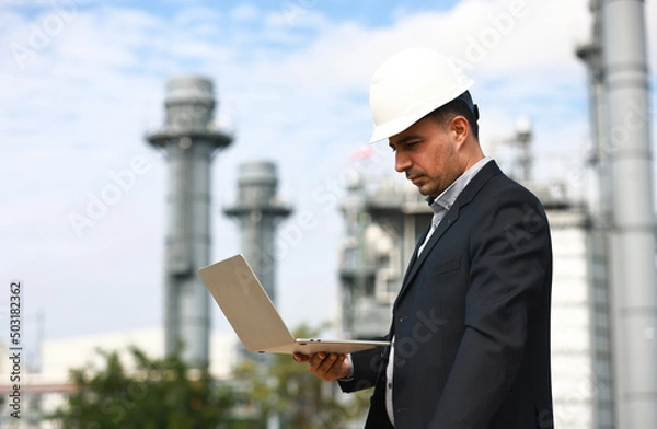 Obraz Business man or senior engineer work on notebook at site line of Cogeneration Power Plant, Industrial and business investment