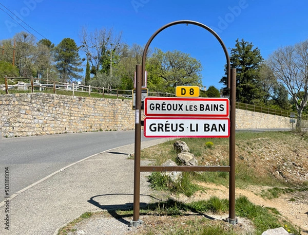Obraz Gréoux-les-Bains, France - April 27, 2022: City entrance sign of Gréoux-les-Bains, a commune in the Alpes-de-Haute-Provence department in France.