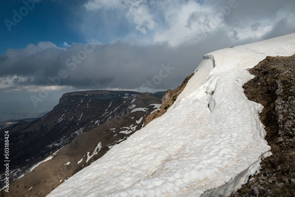 Obraz snow-covered slope in the mountains and beautiful clouds