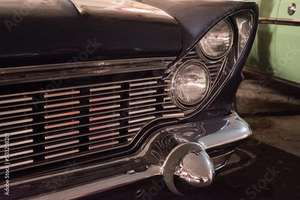 Fototapeta A headlight and a shiny car bumper