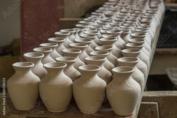 Fototapeta Handmade vases, cups arranged next to each other ready for firing