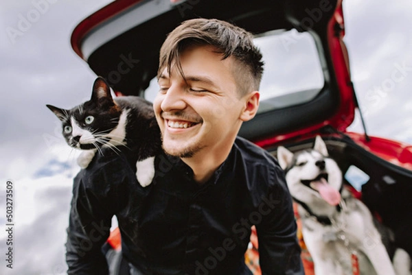Fototapeta Husband cat on shoulders and husky dog in the background in the car.