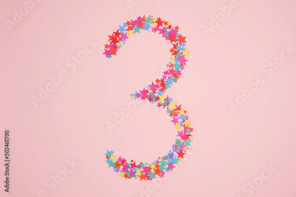 Fototapeta Number 3 or three made from decorative multi-colored stars. Holiday numbers or figures. Top view