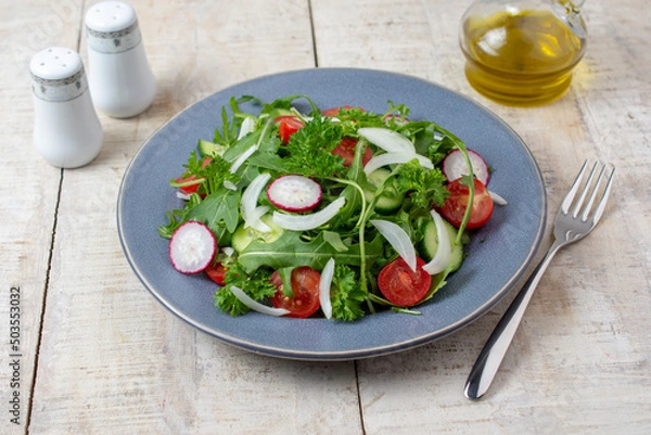 Fototapeta Spring vegan salad with spinach, cherry tomatoes, corn salad, baby spinach, cucumber and radish. Healthy food concept. Gray stone table. Top view. 