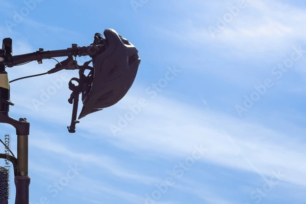 Obraz Helmet hanging from bicycle handlebars