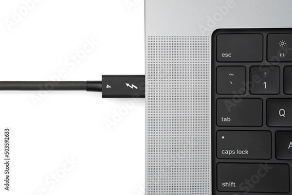 Obraz Thunderbolt 4 Cable Plugged Into Open Charging Laptop Computer Isolated on White Background with Shadow