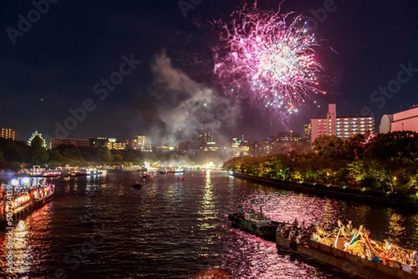 Fototapeta Purple fireworks explode over riverside at summer festival
