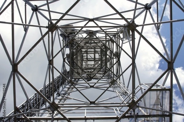 Fototapeta  metal structure of antenna mast under sky with clouds