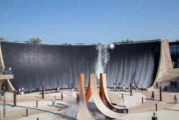 Fototapeta artificial waterfall with water running and people standing in the water