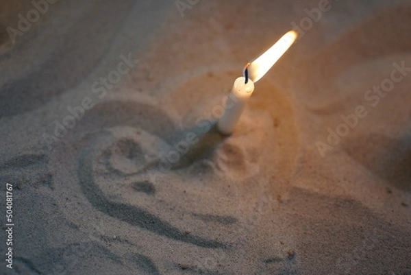 Obraz Commemorative burning candle stuck in the sand, surrounded by a heart sign