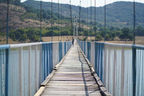 Obraz Male silhouette in the middle of an endless rope bridge