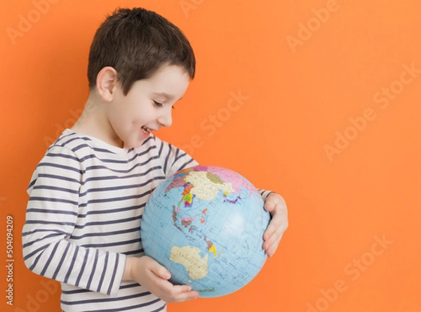 Obraz Boy with globe on orange background