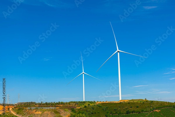 Fototapeta Renewable energy wind turbines windmill isolated on the beautiful blue sky and on the tea fields in Da Lat city, Lam Dong, Viet Nam