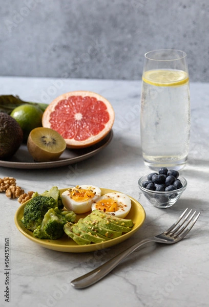 Fototapeta Healthy breakfast to improve metabolism with boiled eggs, vegetables, fruits, seeds and nuts.