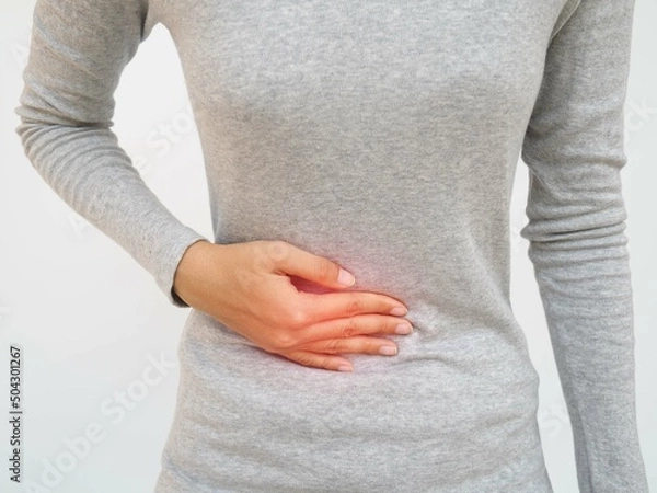 Obraz Woman with stomach pain causes of abdominal pain include inflammatory bowel disease-IBD. stomach ulcer irritable bowel syndrome (IBS), ulcerative colitis and microvilli. closeup photo, blurred.