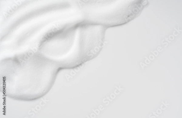Fototapeta Skincare cleanser foam texture. Copy space and soap bubbles on white background.