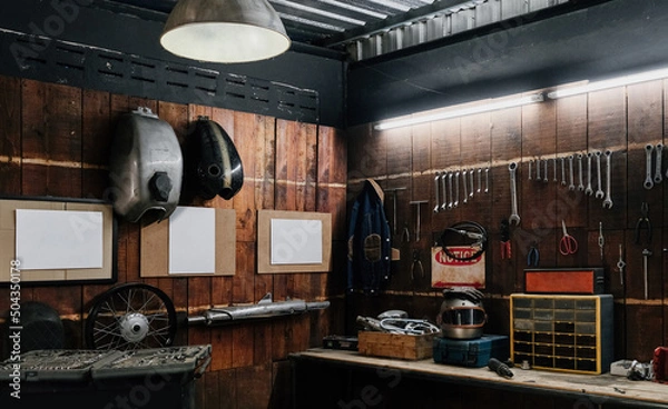 Fototapeta Workshop scene. Old tools hanging on wall in workshop, Tool shelf against a table and wall, vintage garage style